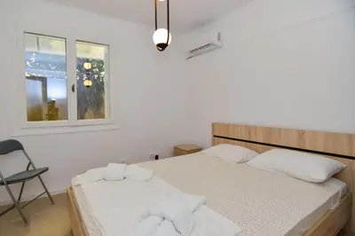 a bedroom with a bed and a chair and a window at Athenian Riviera budget friendly 2 minutes to the beach tram in Athens
