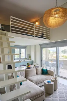 a living room with a couch and a staircase at Christiana Luxury Apartments in Palaiá Fókaia