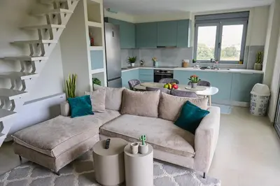 a living room with a couch and a kitchen at Christiana Luxury Apartments in Palaiá Fókaia