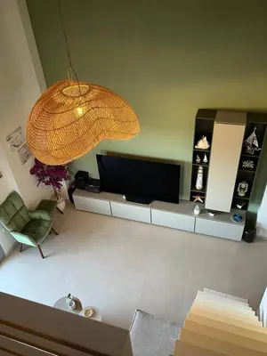 a living room with a television and a chandelier at Christiana Luxury Apartments in Palaiá Fókaia