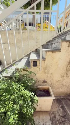 a wooden planter sitting under a stairs with a bench at Filellinon in Athens