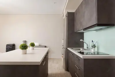 a kitchen with brown cabinets and a white counter top at Villa Nefeli Athenian Riviera in Anavissos