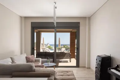 a living room with a couch and a table at Villa Nefeli Athenian Riviera in Anavissos