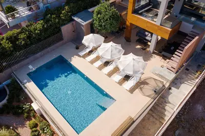 an overhead view of a swimming pool with lounge chairs and a swimming pool at Villa Nefeli Athenian Riviera in Anavissos