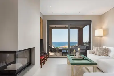 a living room with a couch and a fireplace at Villa Nefeli Athenian Riviera in Anavissos