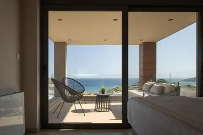 a bedroom with a bed and a view of the ocean at Villa Nefeli Athenian Riviera in Anavissos