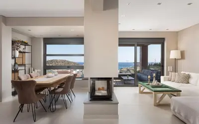 a living room with a table and a fireplace at Villa Nefeli Athenian Riviera in Anavissos