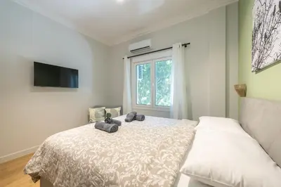 a bedroom with a bed and a window at Tiko Nina by Greece Apartments in Athens