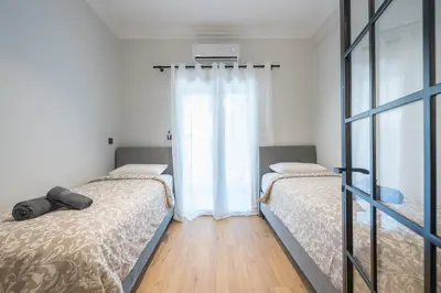 a bedroom with two beds and a window at Tiko Nina by Greece Apartments in Athens
