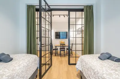 a bedroom with two beds and a dining room at Tiko Nina by Greece Apartments in Athens