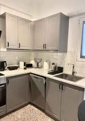 a kitchen with white cabinets and a sink at Kypseli Modern Nest in Athens