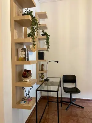 a glass table and a chair in a room at Kypseli Modern Nest in Athens