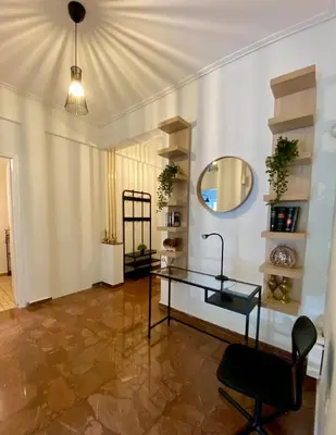 a room with a glass table and a mirror at Kypseli Modern Nest in Athens