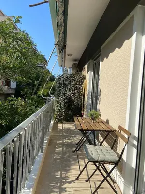 a balcony with a wooden table and chairs on it at Kypseli Modern Nest in Athens