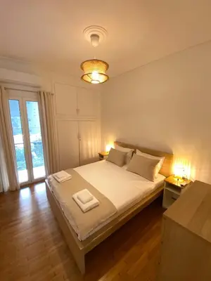 a bedroom with a large white bed with two lamps at Kypseli Modern Nest in Athens