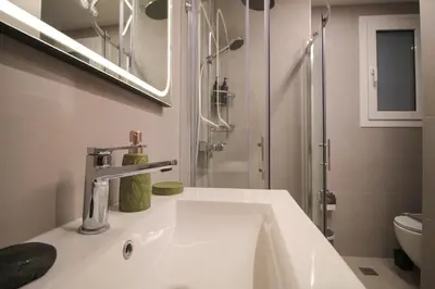 a white bathroom with a sink and a shower at The Athenian Hive in Athens