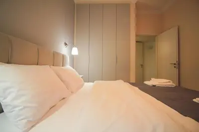 a bedroom with a bed with white sheets and a mirror at The Athenian Hive in Athens