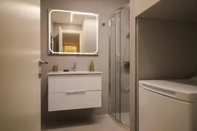a bathroom with a sink and a shower with a mirror at The Athenian Hive in Athens