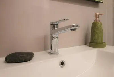 a bathroom sink with a faucet and a soap at The Athenian Hive in Athens