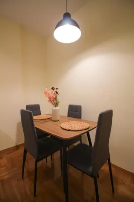 a dining room table with chairs and a vase with flowers at The Athenian Hive in Athens