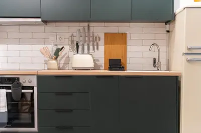 a kitchen with black cabinets and a counter top at 2BR Designer Apt Near Metro With Private Garden in Athens