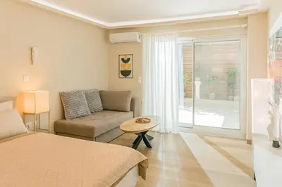 a bedroom with a bed and a couch and a table at Plantaea Deluxe Studio - Athens Modern Escape in Athens
