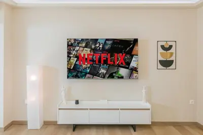 a living room with a white table and a movie poster at Plantaea Deluxe Studio - Athens Modern Escape in Athens