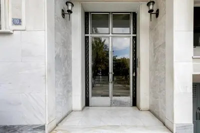 an entrance to a white building with a glass door at Plantaea Deluxe Studio - Athens Modern Escape in Athens