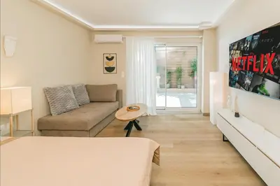a living room with a couch and a table in it at Plantaea Deluxe Studio - Athens Modern Escape in Athens