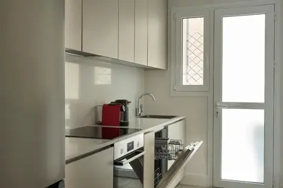 a kitchen with white cabinets and a red appliance at Athens Glow 2bd Apt in Ilisia in Athens
