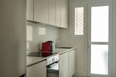 a kitchen with white cabinets and a red appliance at Athens Glow 2bd Apt in Ilisia in Athens