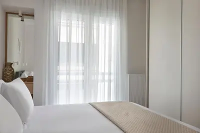 a bedroom with a white bed with a window at Athens Glow 2bd Apt in Ilisia in Athens