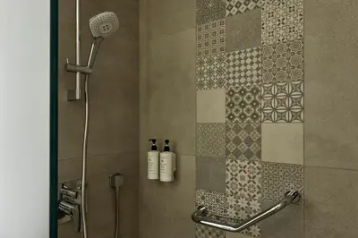 a bathroom with a shower with two bottles on the wall at Athens Glow 2bd Apt in Ilisia in Athens