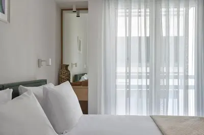 a bedroom with a bed with white pillows and a window at Athens Glow 2bd Apt in Ilisia in Athens