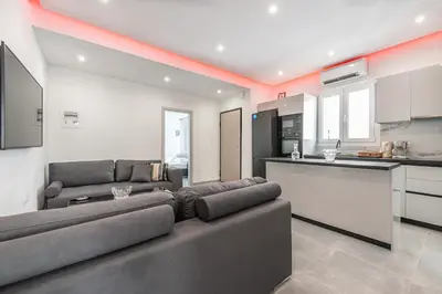 a living room with a couch and a kitchen at Εξαιρετικό διαμέρισμα στη Γλυφάδα in Athens