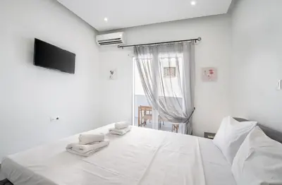 a white bedroom with a bed with towels on it at Εξαιρετικό διαμέρισμα στη Γλυφάδα in Athens