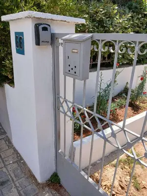 a mail box on the side of a fence at Εξαιρετικό διαμέρισμα στη Γλυφάδα in Athens