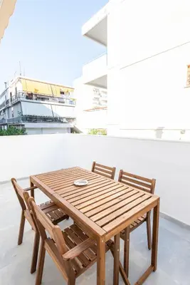 a wooden table and two chairs on a balcony at Εξαιρετικό διαμέρισμα στη Γλυφάδα in Athens