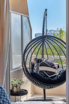 a hanging chair in a room with a window at Voula Urban Escape in Athens