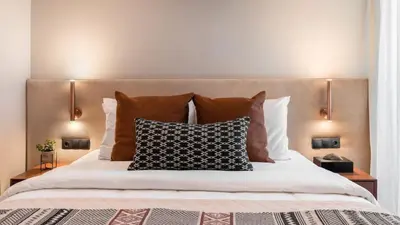 a bedroom with a bed with pillows and two lamps at Voula Urban Escape in Athens