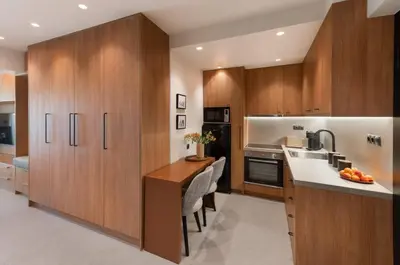 a kitchen with wooden cabinets and a counter top at Voula Urban Escape in Athens