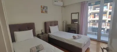 a bedroom with two beds and a window with a view at Marina Zeas Apartment for Big Group in Piraeus