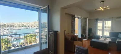 a living room with a balcony with a view of the water at Marina Zeas Apartment for Big Group in Piraeus