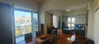 a living room with a table and a view of a city at Marina Zeas Apartment for Big Group in Piraeus
