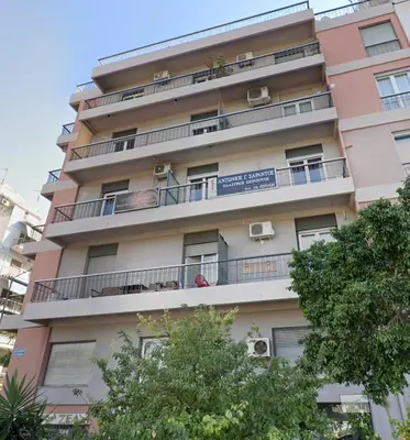 a tall building with balconies and trees in front of it at Marina Zeas Apartment for Big Group in Piraeus