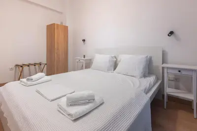 a white bed with two towels on top of it at Elegant 3BDR Apt in Koukaki Near Acropolis in Athens