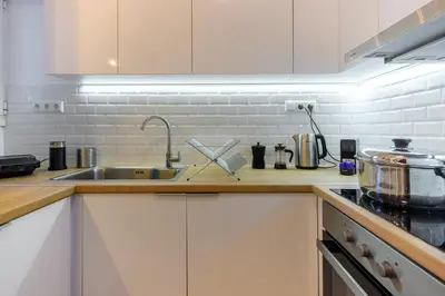 a kitchen with white cabinets and a sink at Elegant 3BDR Apt in Koukaki Near Acropolis in Athens