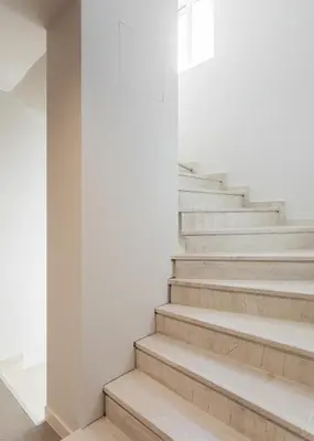 a staircase in a building with white walls and white floors at Link by Zoia Living in Athens
