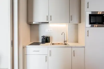 a kitchen with white cabinets and a sink at Link by Zoia Living in Athens