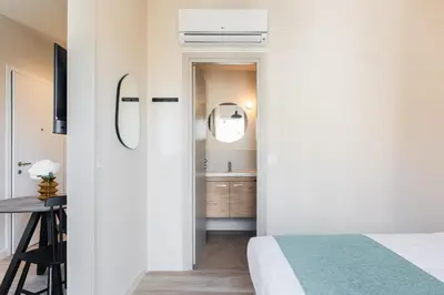 a bedroom with a bed and a bathroom with a sink at Link by Zoia Living in Athens